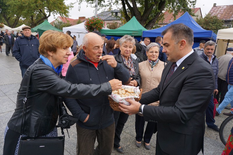 Burmistrz Paweł Marchela dzieli się chlebem. 