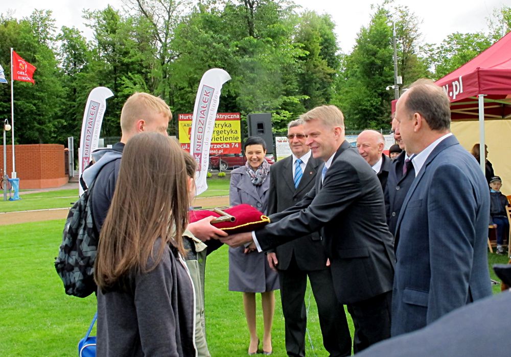 Burmistrz miasta, Dariusz Szustek w asyście łukowskich samorządowców przekazuje reprezentacji młodzieży klucz do symbolicznych bram miasta. Fot. PGL