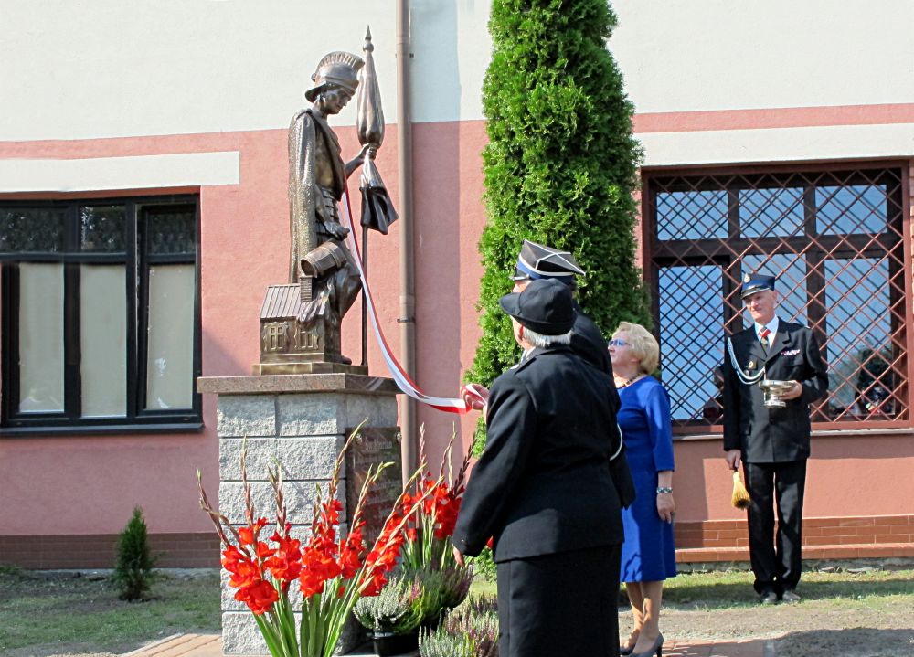 Figurę św. Floriana odsłaniają: (od lewej) Barbara Rosa, Janusz Kozioł i Hanna Stosio. Fot. PGL