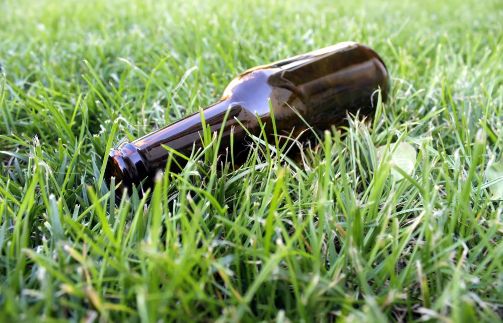 Picie piwa w miejscach publicznych i rzucanie butelek po nim na trawnik nie popłaca. Fot. Heyou Relax, pixabay.com