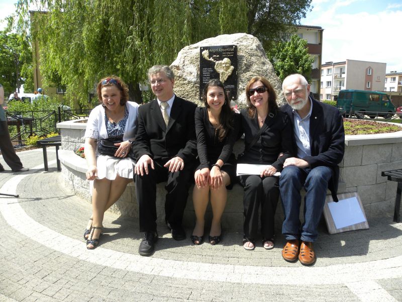 Przed pomniczkiem siedzą od lewej: Małgorzata Gołoś, Jarosław Grenda, Mariana i Maria Luiza Rosenblat, Jerzy Burski. 